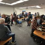 People browse instruments for sale during a musicians swap at the 50th Alaska Folk Festival at Centennial Hall on Saturday. (Mark Sabbatini / Juneau Empire)