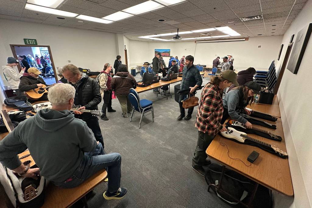 People browse instruments for sale during a musicians swap at the 50th Alaska Folk Festival at Centennial Hall on Saturday. (Mark Sabbatini / Juneau Empire)