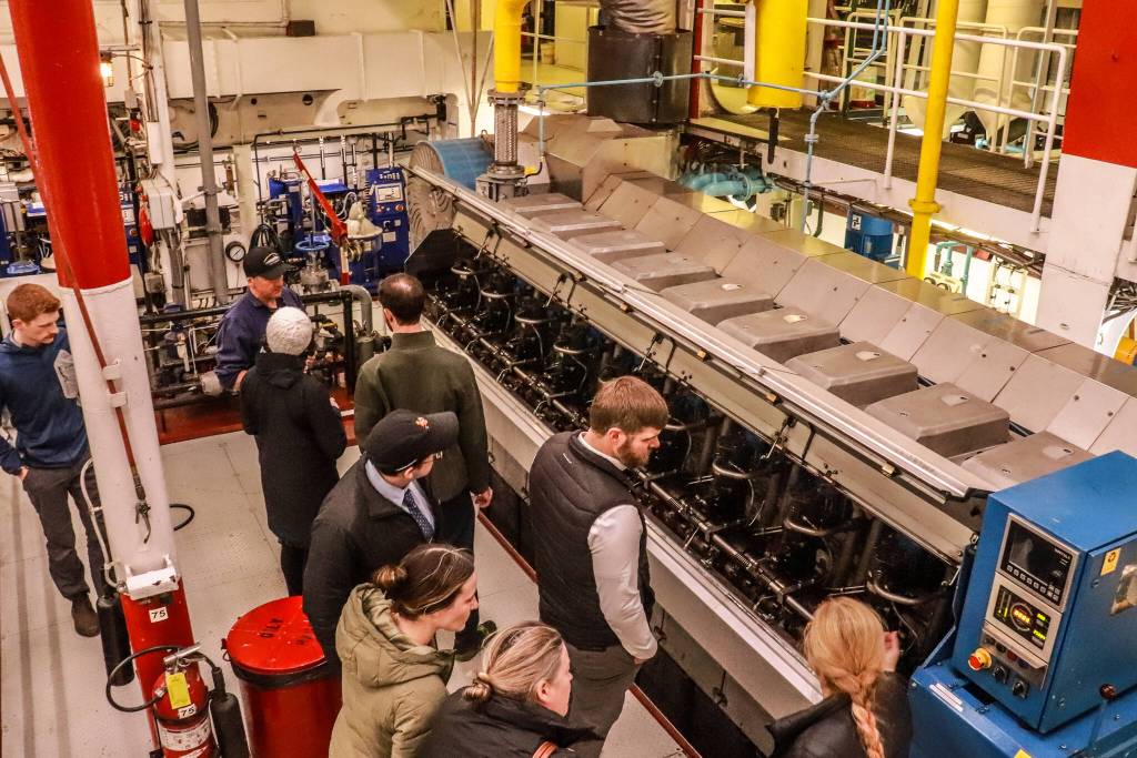 Josh Chevalier, chief engineer of the MV Columbia, opens hot boxes to show the legislators the fuel rack, its connection to the governor, and the individual fuel pumps to each cylinder of each engine, as well as the associated high-pressure fuel piping to the fuel injectors. Each cylinder has one injector, also accessed in the hot box. (Jasz Garrett / Juneau Empire)