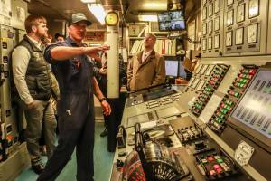 Josh Chevalier, chief engineer of the MV Columbia, shows legislators the engine control room, and explains the control and monitoring systems on Tuesday, April 8, 2025. (Jasz Garrett / Juneau Empire)