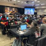 Delegates at the Central Council of the Tlingit and Haida Indian Tribes of Alaskas 90th Tribal Assembly watch a prerecorded speech by U.S. Rep. Nick Begich III (R-Alaska) on Wednesday, April 16, 2025, at Elizabeth Peratrovich Hall. (Mark Sabbatini / Juneau Empire)