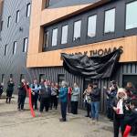Edward Thomas, center, cuts the ribbon during the official unveiling of a building renovated and renamed after him during a ceremony Wednesday, April 16, 2025. The building is used for tribal court, administrative and other purposes by the Central Council of the Tlingit and Haida Indian Tribes of Alaska, which Thomas is a past president of. (Mark Sabbatini / Juneau Empire)