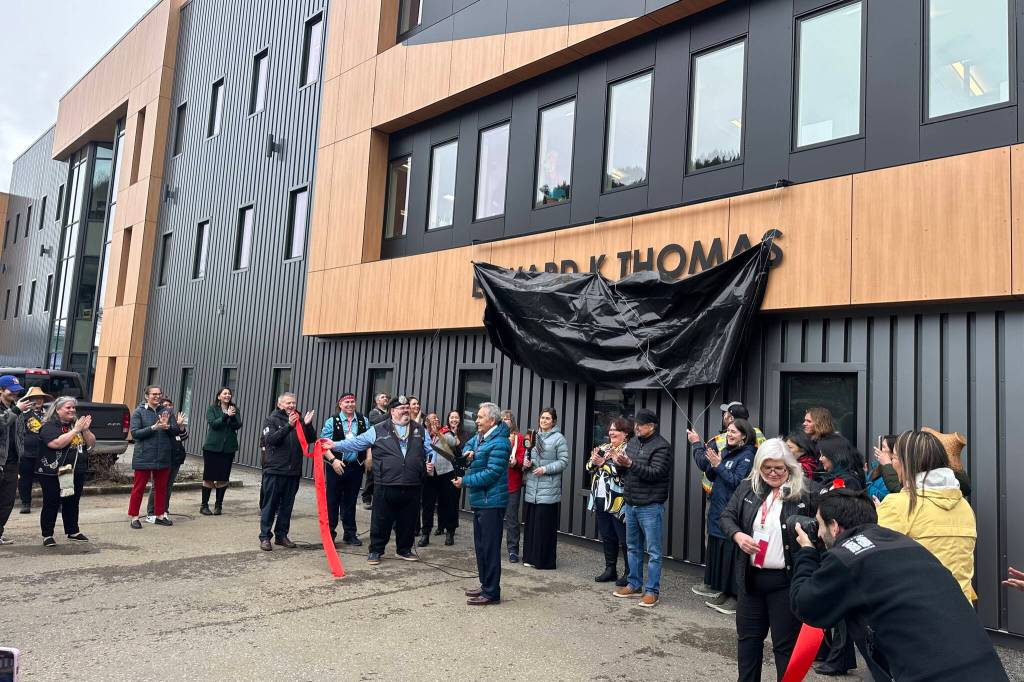 Edward Thomas, center, cuts the ribbon during the official unveiling of a building renovated and renamed after him during a ceremony Wednesday, April 16, 2025. The building is used for tribal court, administrative and other purposes by the Central Council of the Tlingit and Haida Indian Tribes of Alaska, which Thomas is a past president of. (Mark Sabbatini / Juneau Empire)