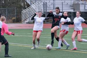 Juneau-Douglas High School: Yadaa.at Kalé junior Kenzie Simonson (7) scores under pressure from West Valley juniors Evyn Bowen (11), Anna Baysinger (4) and Lola Seitz (7) during the Crimson Bears 5-2 loss to the Wolfpack on Friday at Adair Kennedy Park. The teams play again at 10 a.m. Saturday. (Klas Stolpe / Juneau Empire).