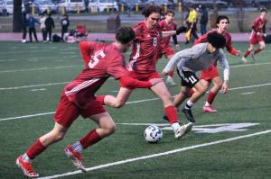 JDHS junior Jesper Bennetsen (8) clears a ball past West Valley senior Diego Guevara (11) as JDHS freshman Bryce Haygood (15) and senior Kellen Chester react during the Crimson Bears 1-0 win over the Wolfpack on Friday at Adair Kennedy Park. The teams play again at noon Saturday. (Klas Stolpe / Juneau Empire).