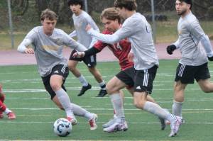 Juneau-Douglas High School: Yadaa.at Kalé senior Kai Ciambor (14) works for a ball among West Valley defenders during the Crimson Bears 4-1 win over the Wolfpack on Saturday at Adair Kennedy Park. (Klas Stolpe / Juneau Empire).