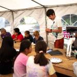 Shawn Merry shows youths during a Sustainable Southeast Partnership culture camp how to use a microscope. He has worked with many community driven programs catalyzed through SSP including the Alaska Youth Stewards Program, KeexKwaan Community Forest Partnership, and now is working full time with the Organized Village of Kake. (Photo by Bethany Goodrich)