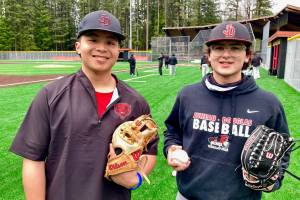 Juneau-Douglas High School: Yadaa.at Kalé seniors JJ McCormick and Jacob Katasse pose for a photo at the Crimson Bears practice Tuesday at Adair Kennedy Memorial Park. McCormick, a former Thunder Mountain player, and Katasse, a returning JDHS player, signify the new combined team building for the Crimson Bears. (Klas Stolpe / Juneau Empire)
