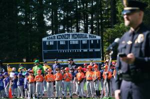Gastineau Channel Little League players listen as Juneau Police Chief Derek Bos speaks during Saturdays GCLL Opening Day, and field grand reopening and rededication at Adair Kennedy Memorial Park. (Klas Stolpe / Juneau Empire)
