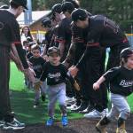 Gastineau Channel Little League youth players are welcomed onto the field by the Juneau-Douglas High School: Yadaa.at Kalé Crimson Bears baseball team during during Saturdays GCLL Opening Day, and field grand reopening and rededication at Adair Kennedy Memorial Park. (Klas Stolpe / Juneau Empire)