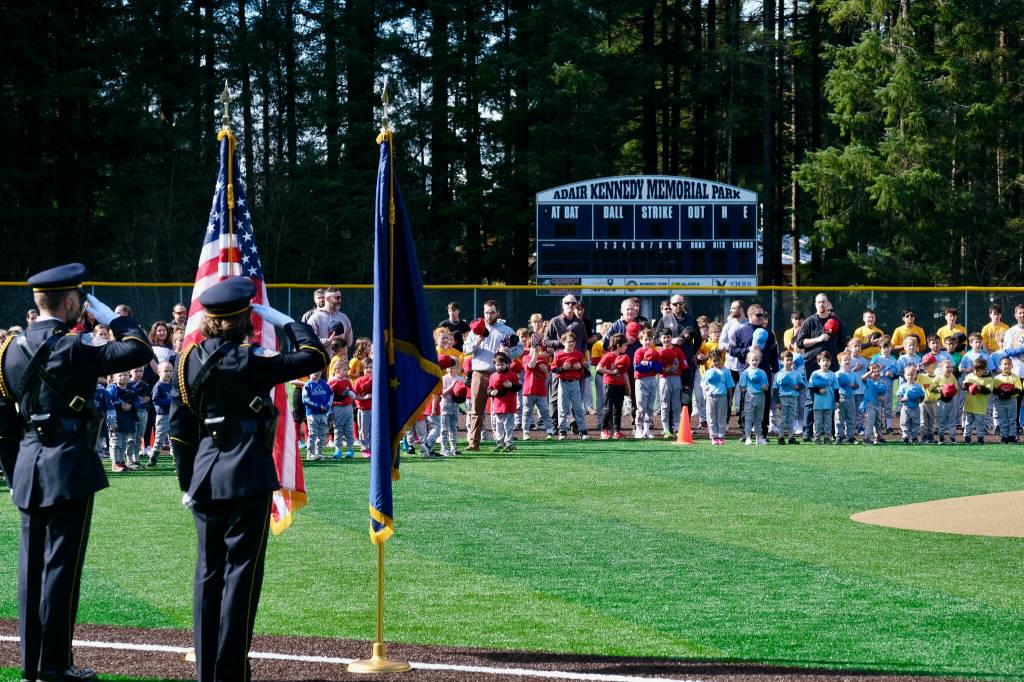 The Juneau Police Honor Guard render a salute during the National Anthem at Saturdays Gastineau Channel Little League Opening Day and field grand reopening and rededication at Adair Kennedy Memorial Park. (Klas Stolpe / Juneau Empire)