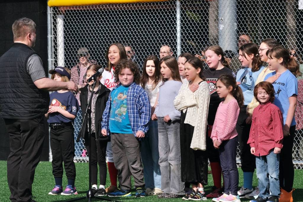 The Juneau Youth Choir sings the National Anthem during Saturdays Gastineau Channel Little League Opening Day, and field grand reopening and rededication at Adair Kennedy Memorial Park. (Klas Stolpe / Juneau Empire)