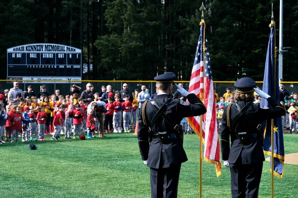 The Juneau Police Honor Guard render a salute during the National Anthem at Saturdays Gastineau Channel Little League Opening Day, and field grand reopening and rededication at Adair Kennedy Memorial Park. (Klas Stolpe / Juneau Empire)