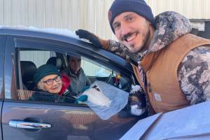Tribal elder lder Ilskyaalas Delores Churchill picks up black cod during a traditional foods distribution by the Central Council of the Tlingit and Haida Indian Tribes of Alaska in Hydaburg earlier this year. (CCTHITA photo)