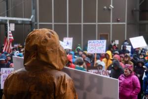 People in Juneau gather in the rain at the Alaska State Capitol for a global May Day protest on Thursday, May 1, 2025. (Jasz Garrett / Juneau Empire)