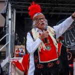 Rosie Taguchi waves a flag given to her moments before by the American Legion while Walter Soboleff Jr. introduces the Haida Eagle song on Saturday, May 3, 2025. (Jasz Garrett / Juneau Empire)