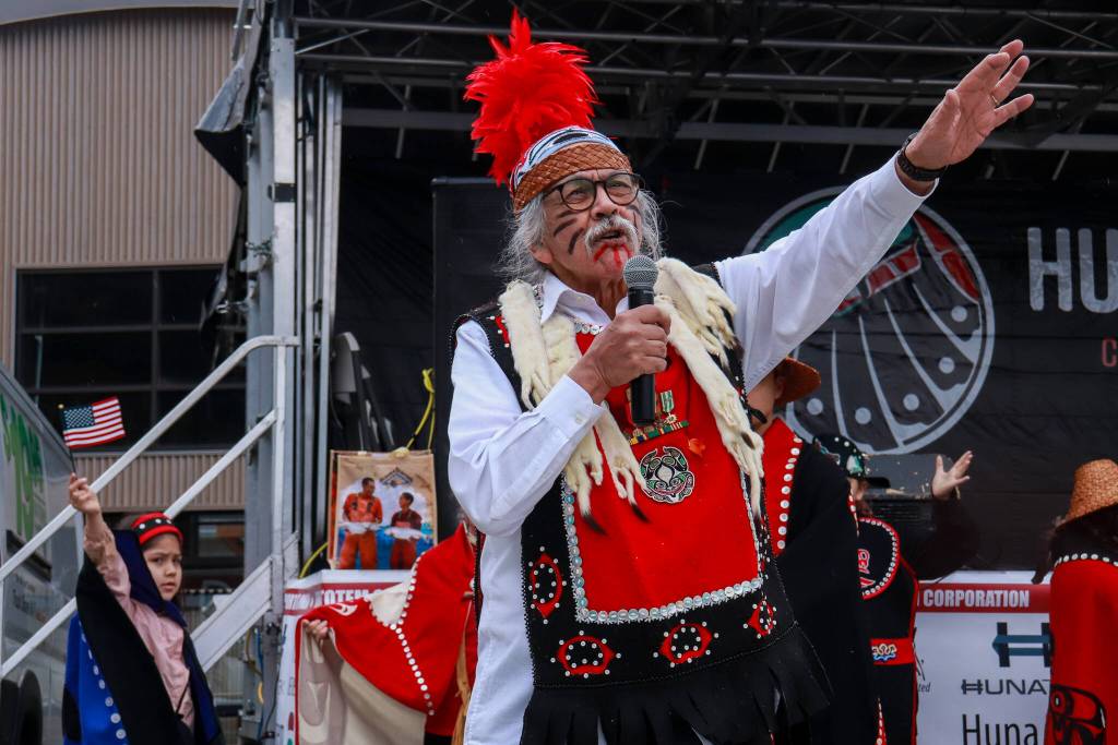 Rosie Taguchi waves a flag given to her moments before by the American Legion while Walter Soboleff Jr. introduces the Haida Eagle song on Saturday, May 3, 2025. (Jasz Garrett / Juneau Empire)