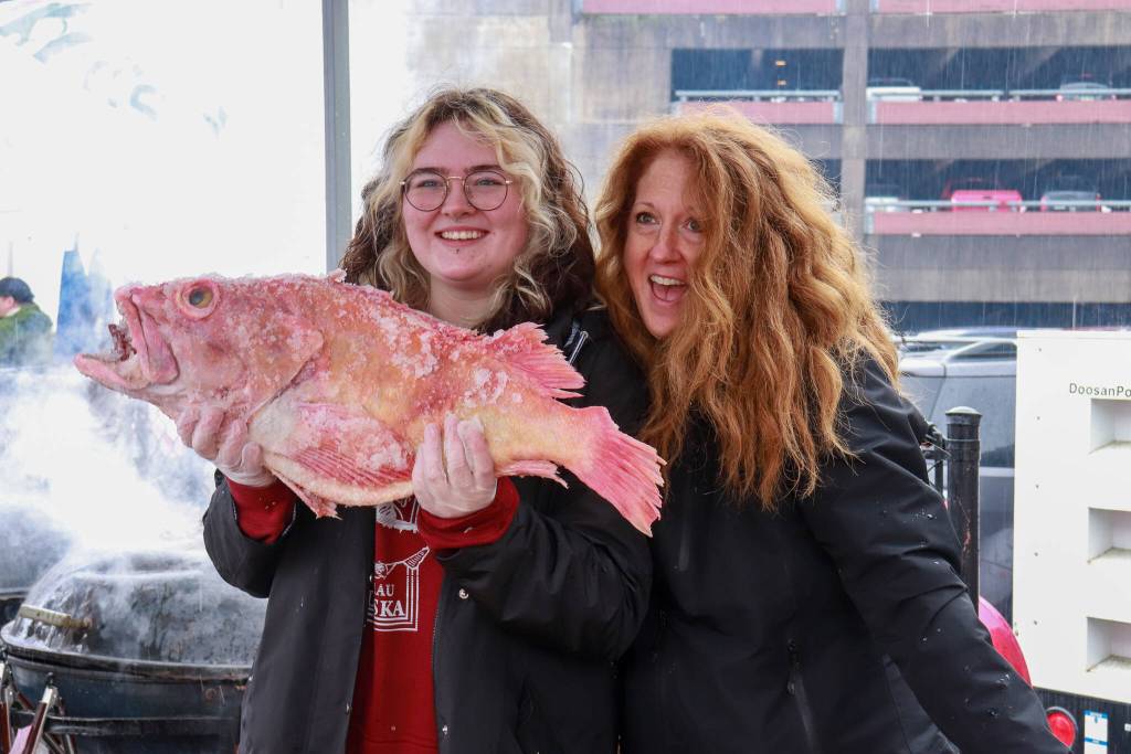 Ava and Sheila Sluka, from Arizona, volunteer with the Twisted Fish at the Juneau Maritime Festival on Saturday, May 3, 2025. (Jasz Garrett / Juneau Empire)