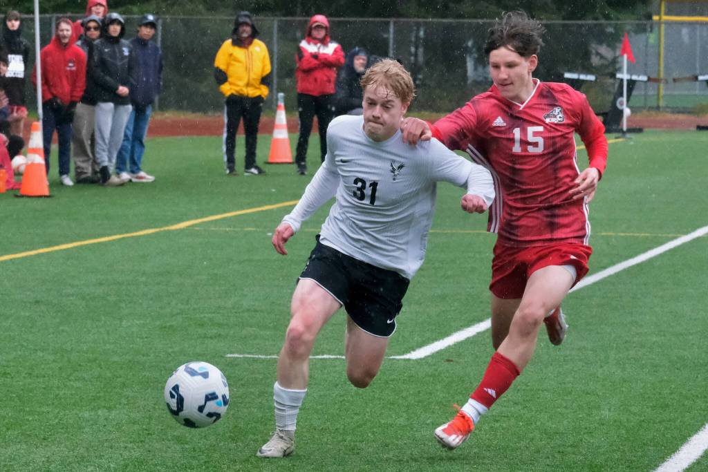 Juneau-Douglas High School: Yadaa.at Kalé freshman Bryce Haygood (15) and West Anchorage senior Tor Miller (31) battle for a ball during the Crimson Bears 7-1 loss to the Eagles on Saturday at Adair Kennedy Memorial Park. (Klas Stolpe / Juneau Empire)