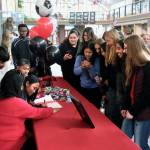 Family, friends and teammates of Juneau-Douglas High School: Yadaa.at Kalé senior Milina Mazon crowd in to watch her sign a Northwest Athletic Conference Letter of Intent on Monday in the JDHS commons to attend Edmonds College in Lynnwood, Washington, and play soccer for the Tritons. (Klas Stolpe / Juneau Empire)