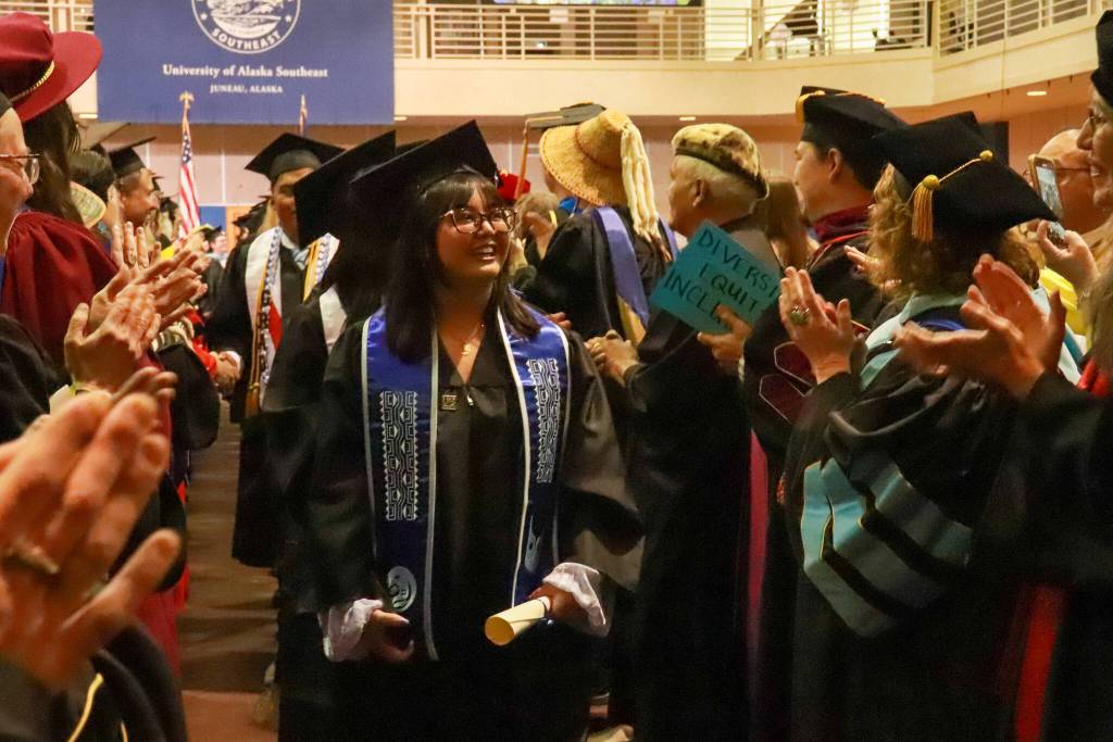 Charlene Zanoria, who graduated with a Bachelor of Arts in social sciences, walks past University of Alaska Southeast faculty after the commencement ceremony concludes on Sunday, May 4, 2025. (Jasz Garrett / Juneau Empire)