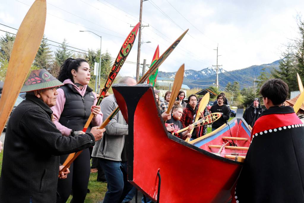 Wayne Price, master carver, (left) dances with his healing dugout canoe at Twin Lakes beside the community healing totem Kaasei Satú in a show of solidarity on Monday, May 5, 2025. (Jasz Garrett / Juneau Empire)
