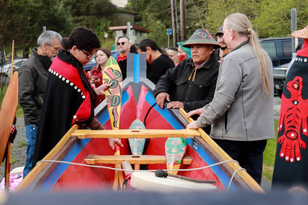 People attending a Missing and Murdered Indigenous Persons Remembrance Ceremony place paddles back into a healing dugout canoe after a dance on Monday, May 5, 2025. (Jasz Garrett / Juneau Empire)