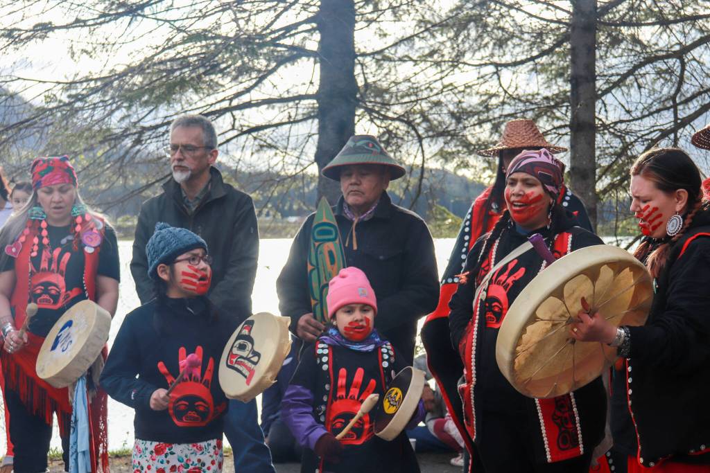 Jes Lxook Kinville-James (far right) leads the Stolen Prayers song on Monday, May 5, 2025. Kanaagoot Mike Kinvilles t-shirt, sponsored by Sealaska Heritage Institute, is worn. (Jasz Garrett / Juneau Empire)