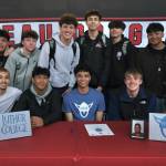 Juneau-Douglas High School: Yadaa.at Kalé senior Pedrin Saceda-Hurt signed an NCAA Division III student-athlete form on Wednesday in the JDHS commons to attend Luther College in Decorah, Iowa, and play for the Norse basketball team. Shown are friends and teammates attending. (Klas Stolpe/Juneau Empire)