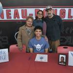 Juneau-Douglas High School: Yadaa.at Kalé senior Pedrin Saceda-Hurt signed an NCAA Division III student-athlete form on Wednesday in the JDHS commons to attend Luther College in Decorah, Iowa, and play for the Norse basketball team. Shown with Pedrin are grandmother Gethsemane Saceda, mother Nickie Saceda-Hurt and father Frank Hurt. (Klas Stolpe/Juneau Empire)