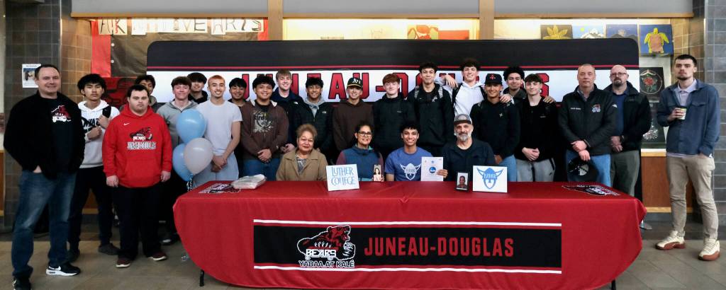 Juneau-Douglas High School: Yadaa.at Kalé senior Pedrin Saceda-Hurt signed an NCAA Division III student-athlete form on Wednesday in the JDHS commons to attend Luther College in Decorah, Iowa and play for the Norse basketball team. Shown are family, friends, coaches and team members attending. (Klas Stolpe/Juneau Empire)