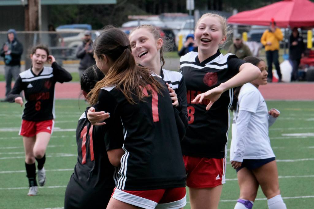 Juneau-Douglas High School: Yadaa.at Kalé senior Milina Mazon (11), junior Kenzie Simonson, junior Peyton Wheeler and sophomore Riley Schultz (8) celebrate a goal by Wheeler during the Crimson Bears 2-1 loss to the Stars on Thursday at Adair Kennedy Memorial Park. (Klas Stolpe/ Juneau Empire)