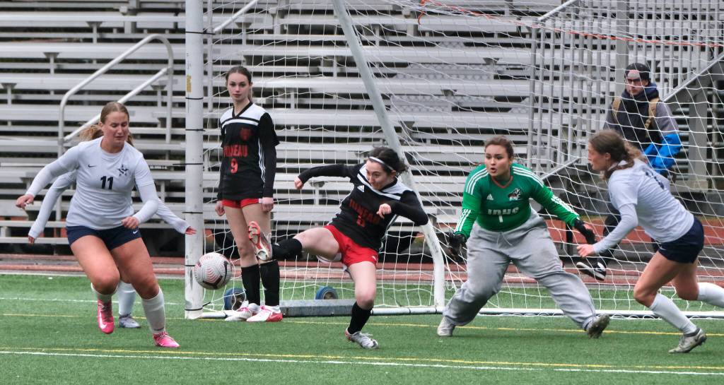 Juneau-Douglas High School: Yadaa.at Kalé senior Adelyn Buss (3) clears a ball from the Crimson Bears box as Soldotna senior Sadie Lane (11) and sophomore Teagen Kobylarz and JDHS senior Ella Orsborn (9) and junior Alba Muir (1) react during the Crimson Bears 2-1 loss to the Stars on Thursday at Adair Kennedy Memorial Park. (Klas Stolpe/ Juneau Empire)