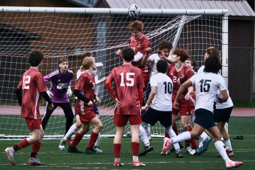 Juneau-Douglas High School: Yadaa.at Kalé senior Reed Maier (19) heads a Soldotna corner kick away during the Crimson Bears 3-0 win over the Stars on Thursday at Adair Kennedy Memorial Park. (Klas Stolpe / Juneau Empire)