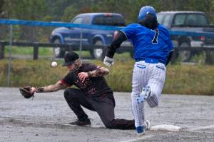 Juneau-Douglas High School: Yadaa.at Kalé junior first baseman Riley Fick (22) attempts to catch an errant throw as Petersburg senior Brian Peterson (7) runs out a hit during the Crimson Bears 12-7 win over the Vikings on Friday at Mort Fryer Ball Park in Petersburg. (Klas Stolpe / Juneau Empire)
