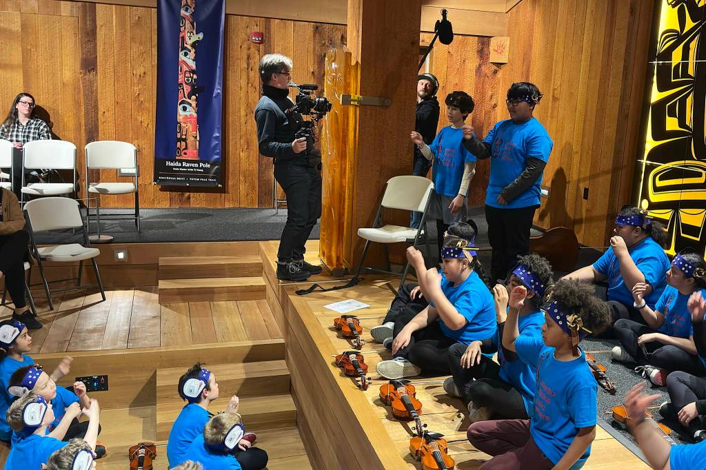 Axel Baumann films and Max Osadchenko captures sounds of Juneau Alaska Music Matters students performing a Gratitude concert at the Sealaska Heritage Institute Clan House on Thursday, May 8, 2025. (Mark Sabbatini / Juneau Empire)