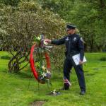 Juneau Police Department Detective Kirt-Stage Harvey stays after the ceremony to place flowers on the grave of fallen JPD officer Richard Adair. The two wreaths laid during the ceremony will reside at the JPD station and the Juneau Alaska State Troopers post. (Jasz Garrett / Juneau Empire)
