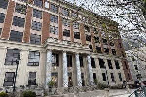 The Alaska State Capitol is seen behind a curtain of blooming branches on Saturday, May 17, 2025. (James Brooks/Alaska Beacon)