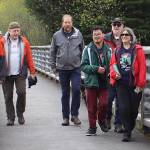 Fu Bao Hartle (center), a Juneau Special Olympics athlete, crosses a bridge with family and supporters during the annual Alaska Law Enforcement Torch Run on Saturday, May 17, 2025. (Ellie Ruel / Juneau Empire)