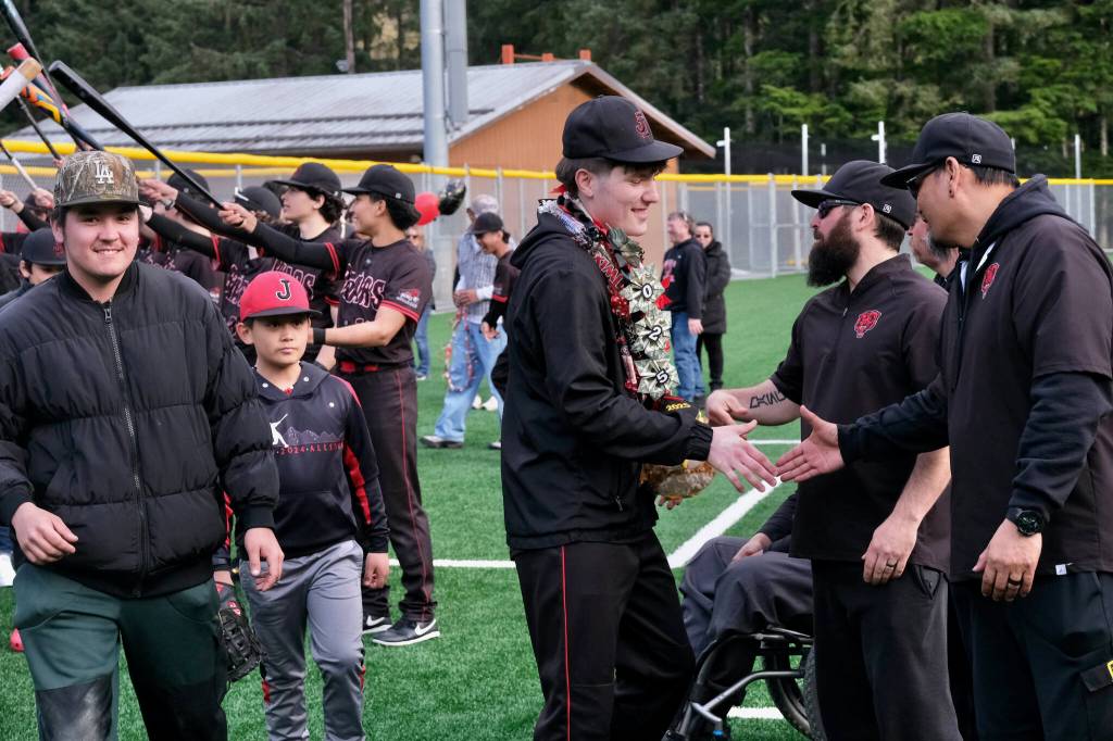 Juneau-Douglas High School: Yadaa.at Kalé senior Christian Nelson shakes hands with coaches during the Crimson Bears’ baseball senior night against Ketchikan on Saturday at Adair-Kennedy Memorial Park. (Klas Stolpe / Juneau Empire)