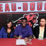 Juneau-Douglas High School: Yadaa.at Kalé senior Ahmir Parker, center, signed a letter of intent Thursday in the JDHS commons to attend Waldorf University in Forest City, Iowa, and play soccer for the Viking Warriors. From left are Parkers maternal grandmother Michelle Monts, mother Kelli Patterson, Ahmir Parker, grandmother Sherry Patterson and little sister Makaylah Patterson. (Klas Stolpe / Juneau Empire)