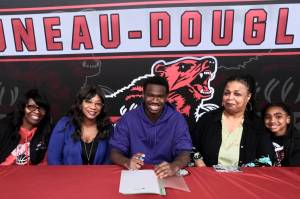 Juneau-Douglas High School: Yadaa.at Kalé senior Ahmir Parker, center, signed a letter of intent Thursday in the JDHS commons to attend Waldorf University in Forest City, Iowa, and play soccer for the Viking Warriors. From left are Parkers maternal grandmother Michelle Monts, mother Kelli Patterson, Ahmir Parker, grandmother Sherry Patterson and little sister Makaylah Patterson. (Klas Stolpe / Juneau Empire)