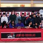 Juneau-Douglas High School: Yadaa.at Kalé senior Ahmir Parker, center, signed a letter of intent Thursday in the JDHS commons among family, friends, coaches and teammates to attend Waldorf University in Forest City, Iowa, and play soccer for the Viking Warriors. (Klas Stolpe / Juneau Empire)