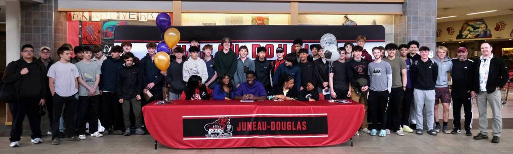 Juneau-Douglas High School: Yadaa.at Kalé senior Ahmir Parker, center, signed a letter of intent Thursday in the JDHS commons among family, friends, coaches and teammates to attend Waldorf University in Forest City, Iowa, and play soccer for the Viking Warriors. (Klas Stolpe / Juneau Empire)