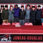 Juneau-Douglas High School: Yadaa.at Kalé senior Ahmir Parker, center, poses with Crimson Bears teammates after signing a letter of intent Thursday in the JDHS commons to attend Waldorf University in Forest City, Iowa, and play soccer for the Viking Warriors. (Klas Stolpe / Juneau Empire)