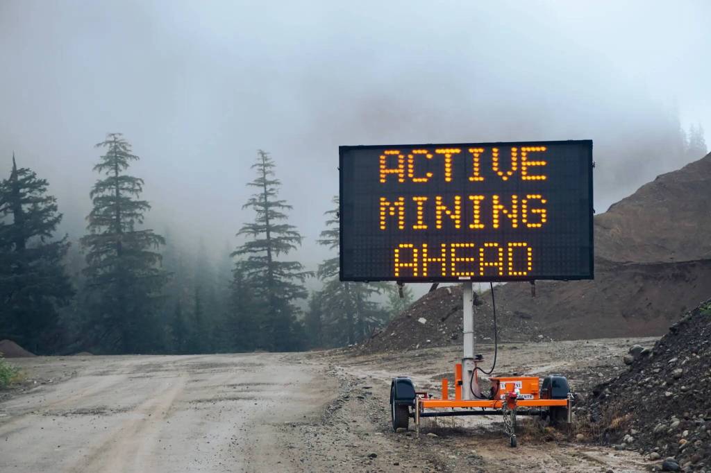 A sign pictured along the Granduc Road near the border of Hyder, Alaska, and Stewart, British Columbia. The area  not far from Meziadin Lake  is a hot spot of mining, melting glaciers, and salmon. (Max Graham/Grist)