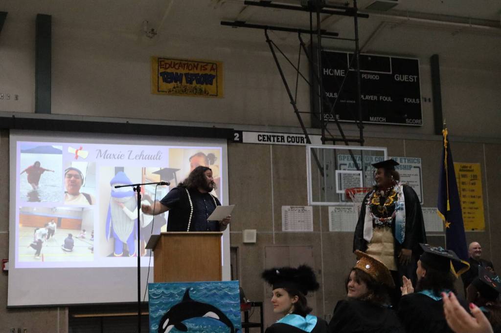 Student speaker Maxie Lehauli (right) listens to advisor Jasper Nelson give a speech before receiving her diploma during Yaaḵoosgé Daakahídi High Schools graduation ceremony Sunday, May 25, 2025, at the Dzantiki Heeni campus. (Ellie Ruel / Juneau Empire)