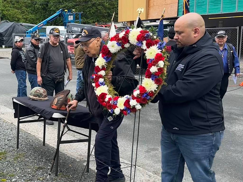Ray Wilson (center), a Korea War veteran who served in the U.S. Army, helps place a wreath at the Southeast Alaska Native Veterans Memorial Park during a Memorial Day ceremony on Monday, May 26, 2025. (Mark Sabbatini / Juneau Empire)
