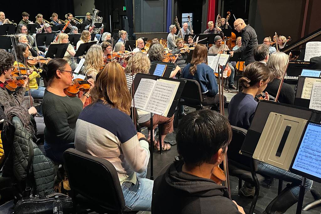 Tigran Arakelyan leads the Juneau Symphony through a rehearsal on Thursday, May 29, 2025, in the Juneau-Douglas High School: Yadaa.at Kalé auditorium. He is among four candidates seeking to become the symphonys new music director. (Mark Sabbatini / Juneau Empire)