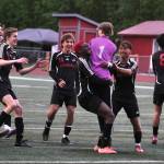 Juneau-Douglas High School: Yadaa.at Kalé Crimson Bears freshman goalkeeper Callen Walker (1) is swarmed by teammates after saving the final shot in a penalty shootout win over Service to open the 2025 ASAA/First National Bank Alaska Soccer State Championships at Wasilla High School on Thursday, May 29, 2025. Senior teammate Kellen Chester (8) consoles Service senior Matej Omalley (2). (Klas Stolpe / Juneau Empire)